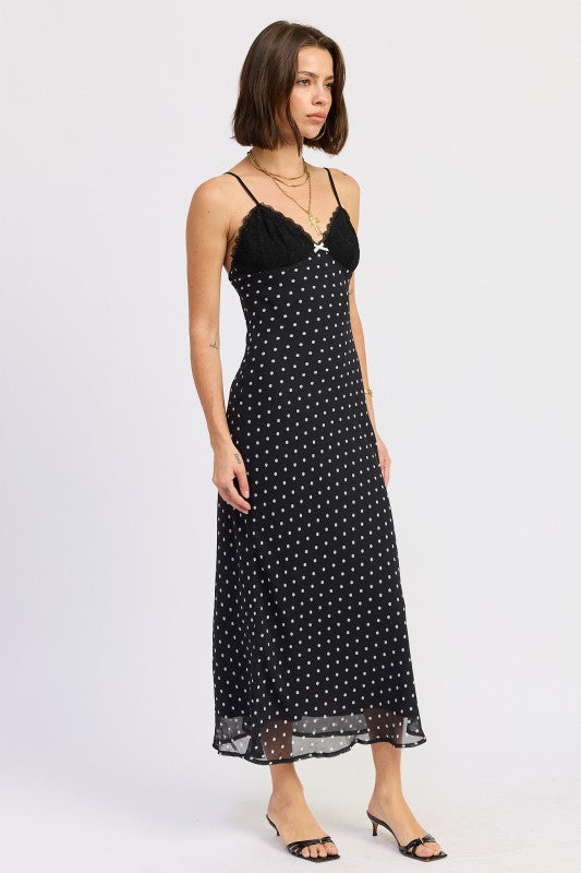 Side view of black polka dot slip dress with lace bust and fitted silhouette.
