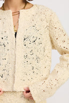 Close-up of Ivory Reverie Textured Cropped Jacket showing swirl knit pattern and soft cream fabric.