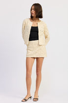 Ivory Reverie Textured Cropped Jacket in cream, styled with mini skirt and black heels for a coordinated look.