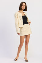 Angled view of Ivory Reverie Textured Mini Skirt showing sculpted silhouette and textured detailing.