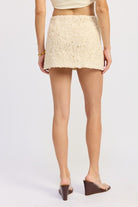 Back view of Ivory Reverie Textured Mini Skirt in cream showing full coverage and detailed texture.