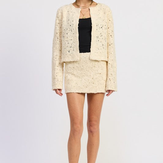 Front view of Ivory Reverie Textured Mini Skirt in cream, styled with matching jacket and black top-AVAH