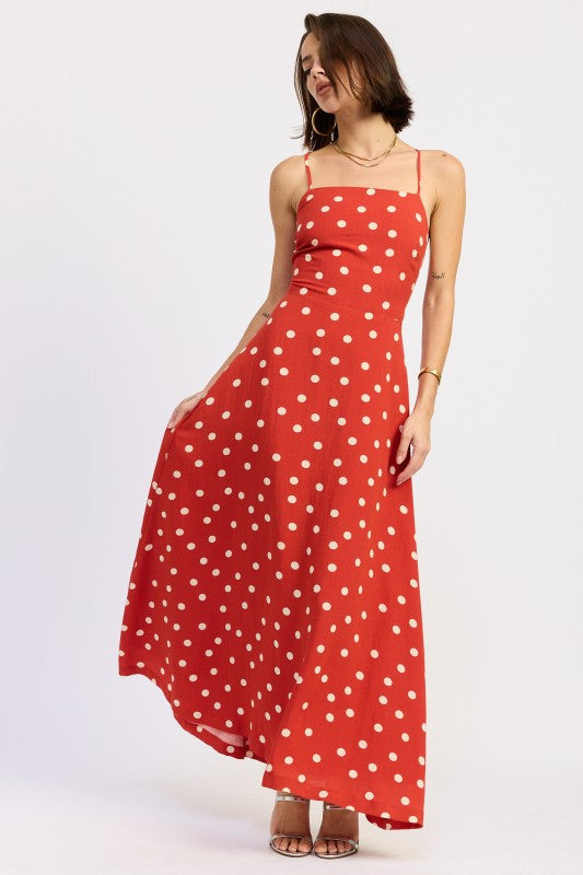 Model in red polka dot maxi dress mid-twirl showing skirt flow.