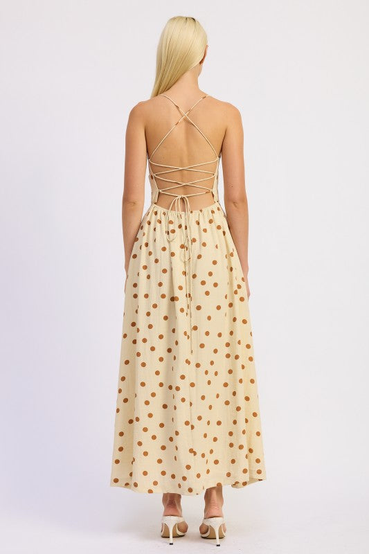 Model wearing the butter cream polka dot dress with open lace-up back and criss-cross ties.