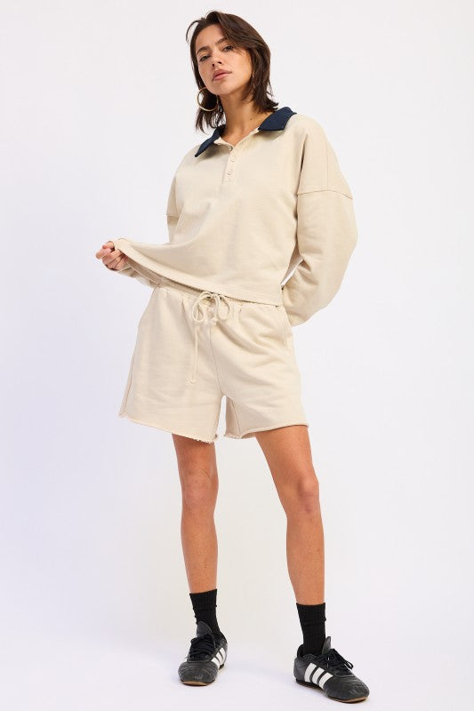 Ivory long sleeve collared top styled with matching shorts and sneakers