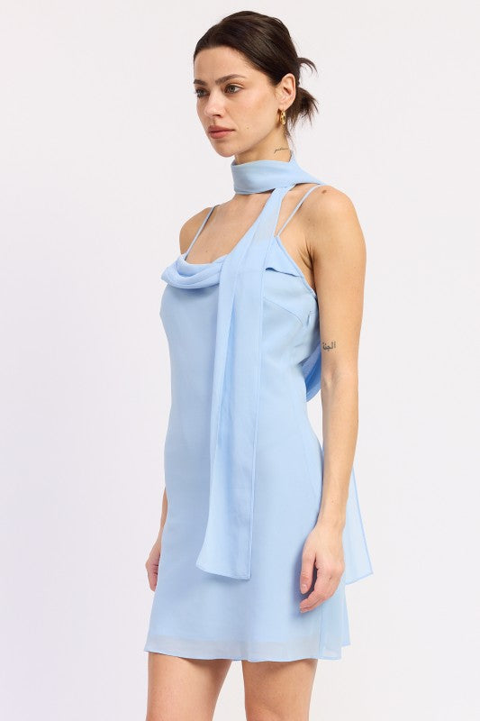 Woman wearing a light blue mini dress with cowl neckline and scarf on a white background front angle view
