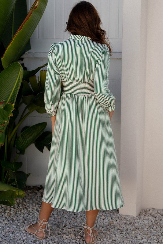 Back view of green striped midi dress showing contrast waistband and relaxed silhouette.