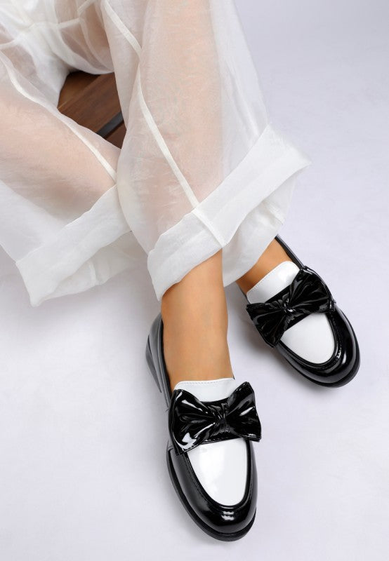 close-up of two-tone loafers with chunky bow detail