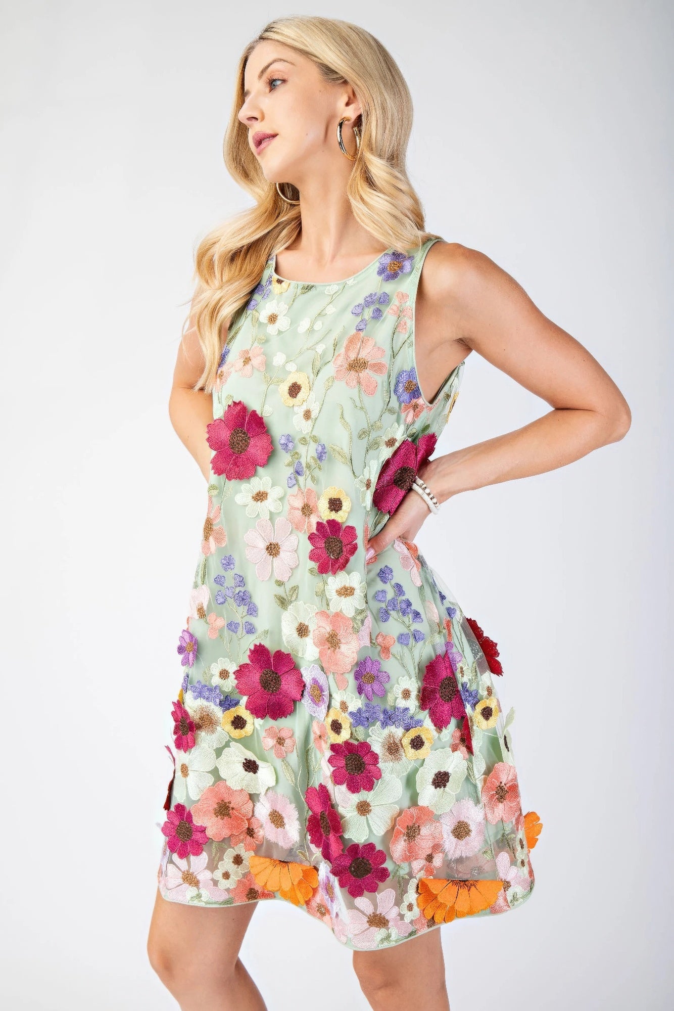 Side view of sage green floral mini dress showcasing colorful 3D embroidered flowers.