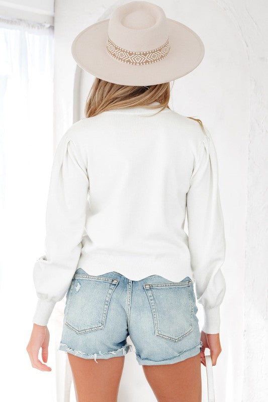 Back view of ivory sweater showing smooth knit texture and long sleeves