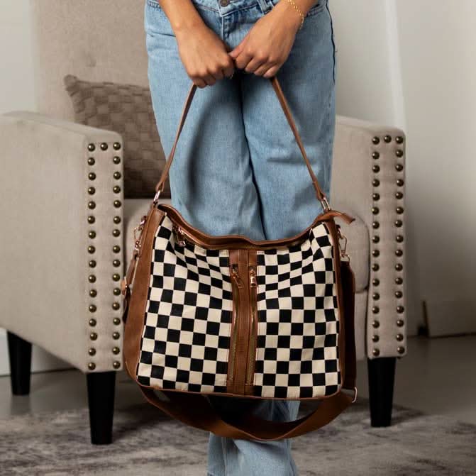 Woman holding cognac checkered hobo bag by its shoulder strap.