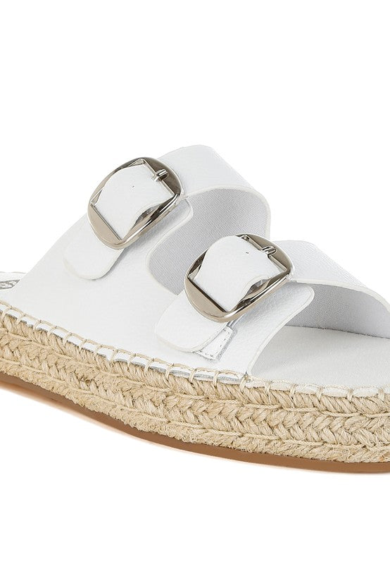 Close-up of white espadrille sandal showing textured leather straps and braided jute sole