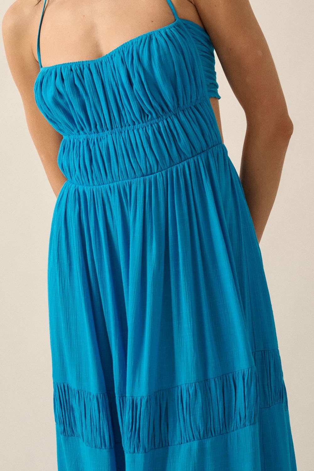 Detail view of the ruched bodice and gathered tiered skirt of the blue Coastal Cascade maxi dress.