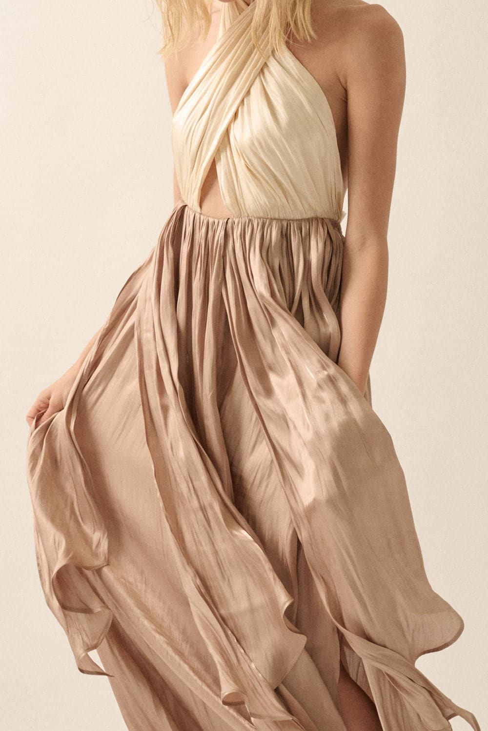 Detailed view of cream pleated crisscross halter bodice and taupe satin layered skirt with soft movement