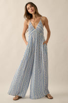 Studio front view of jumpsuit showcasing deep V-neckline, smocked bodice, and wide-leg flow