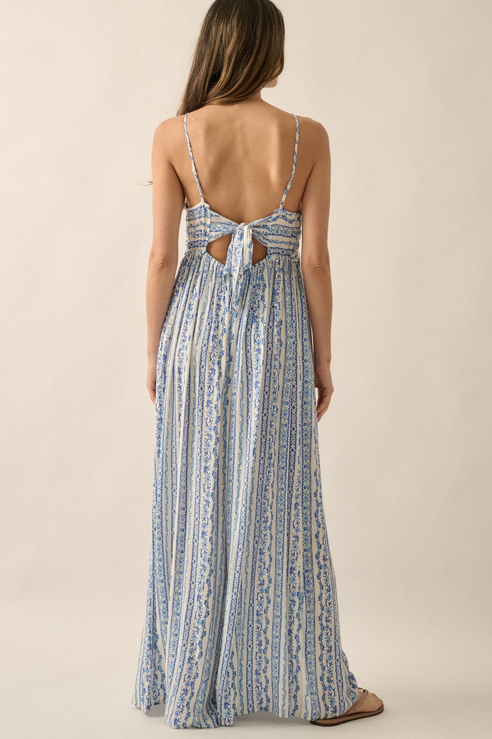 Back view of jumpsuit with self-tie bow, open-back detail, and adjustable cami straps