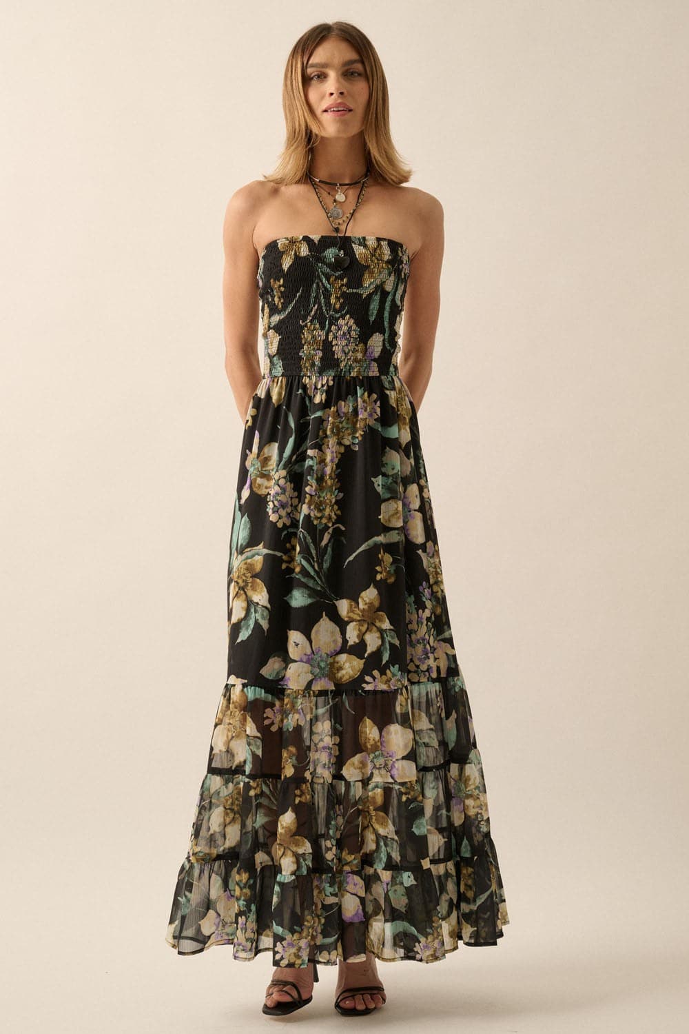 Front studio shot of black strapless floral maxi dress with smocked bodice and layered ruffle skirt
