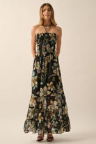 Front studio shot of black strapless floral maxi dress with smocked bodice and layered ruffle skirt