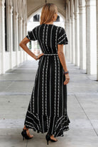 Rear view of black and white striped wrap dress, showcasing high-low hem and soft ruffle detail.