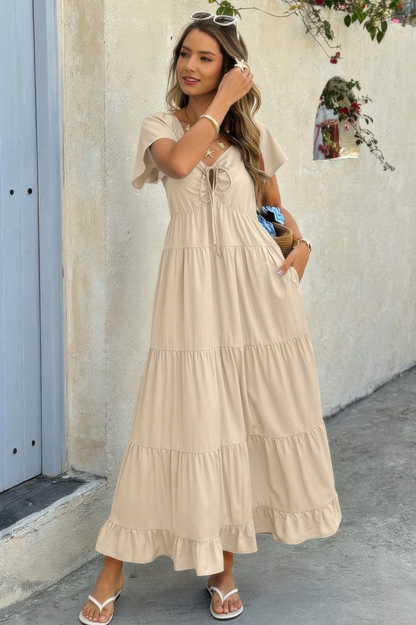 Model in khaki drawstring maxi dress with smocked back and tiered skirt, styled casually with neutral accessories.