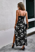 Rear view of black floral dress with adjustable straps and elastic waist detail.