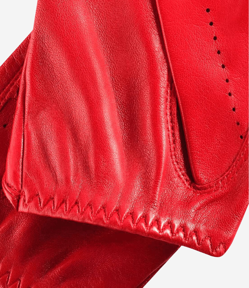 Close-up of a red leather glove with stitching details on a white background