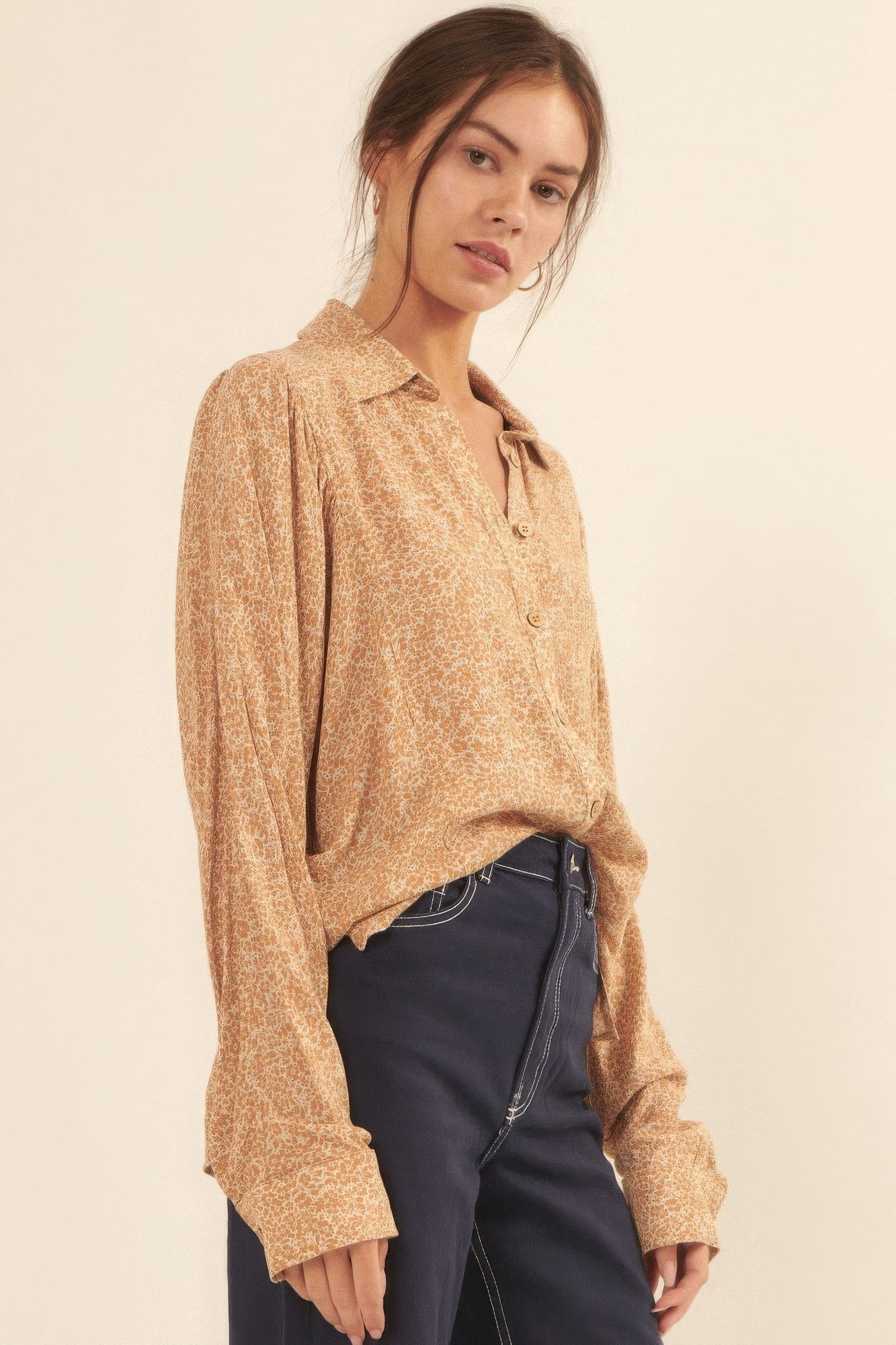 Side view of golden floral collared blouse styled with dark denim-AVAH