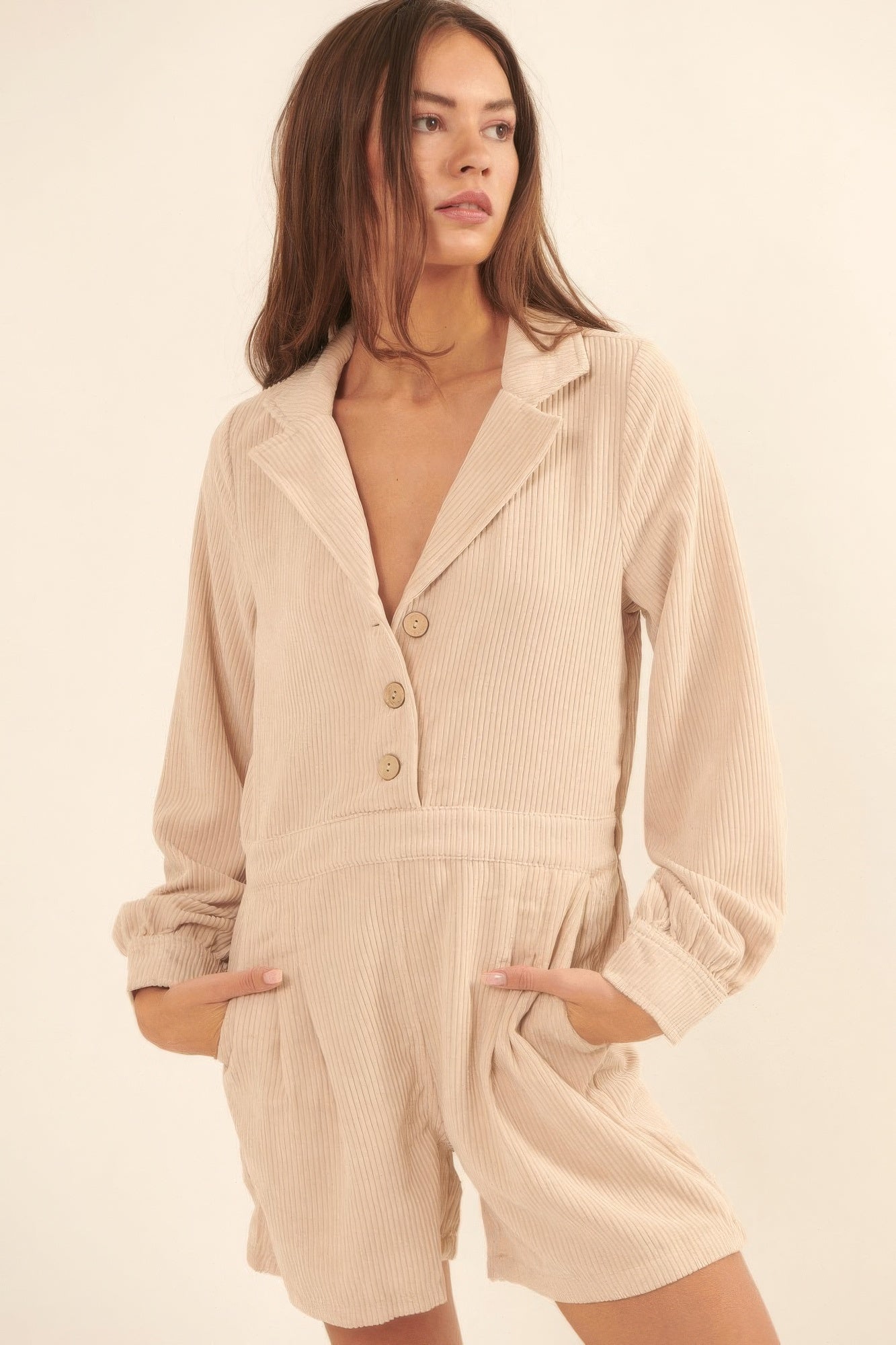 Model wearing cream corduroy romper with long sleeves, button front, and collared neckline-AVAH
