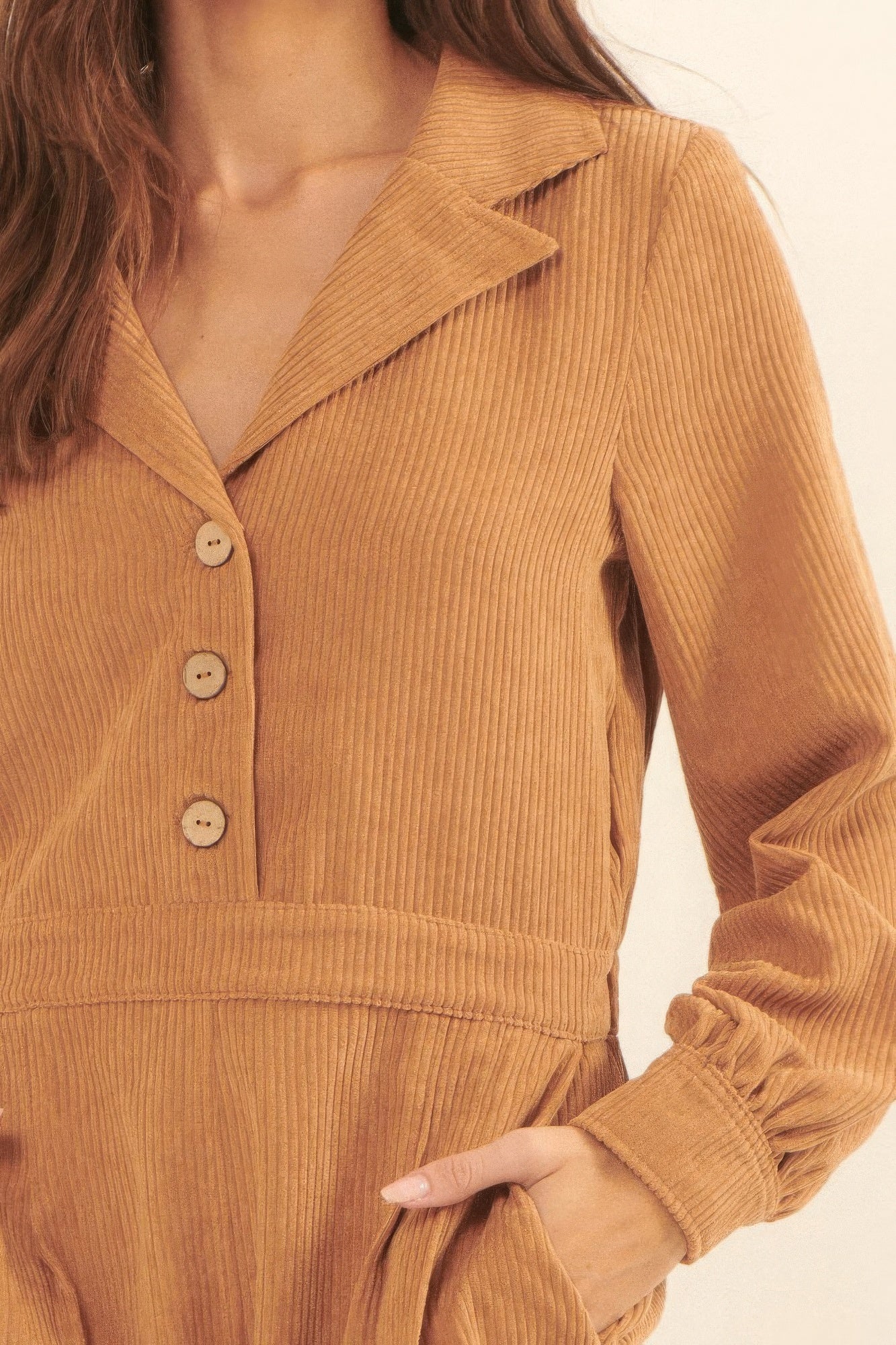 Close-up of the tan corduroy romper highlighting the collared neckline, button closure, and ribbed corded texture-AVAH