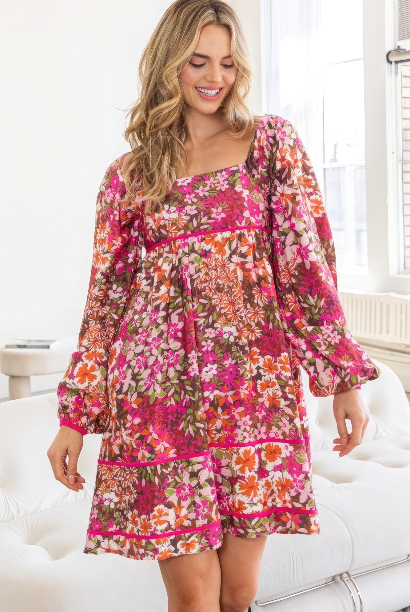 Front view of model in AVAH Vivid Bloom Floral Long Sleeve Mini Dress with square neckline and tiered hem.