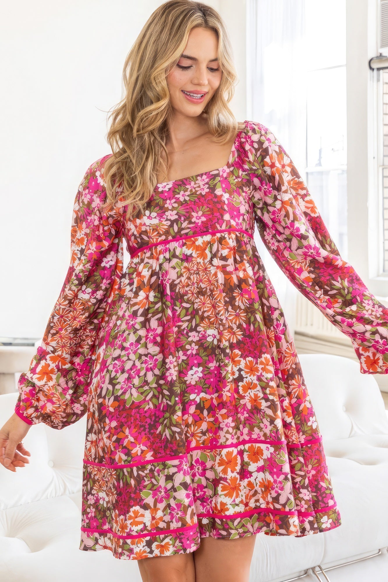 Front view of model in AVAH Vivid Bloom Floral Long Sleeve Mini Dress with square neckline and tiered hem.