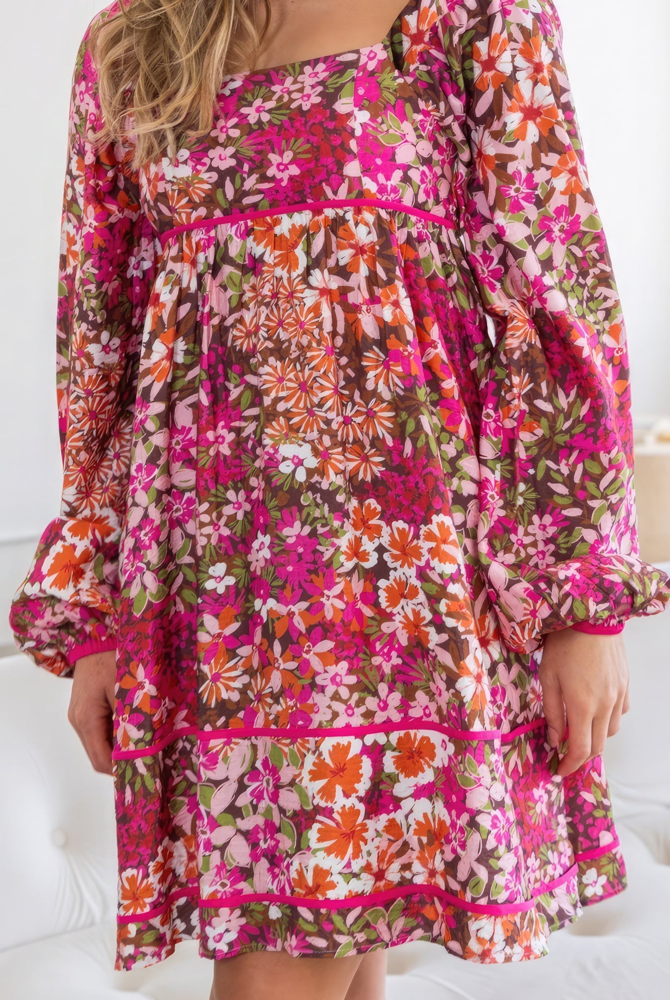 Close-up of AVAH floral long sleeve mini dress highlighting neckline and vibrant print detail.