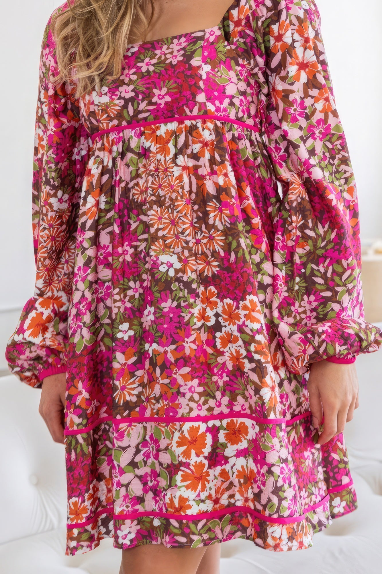 Close-up of AVAH floral long sleeve mini dress highlighting neckline and vibrant print detail.