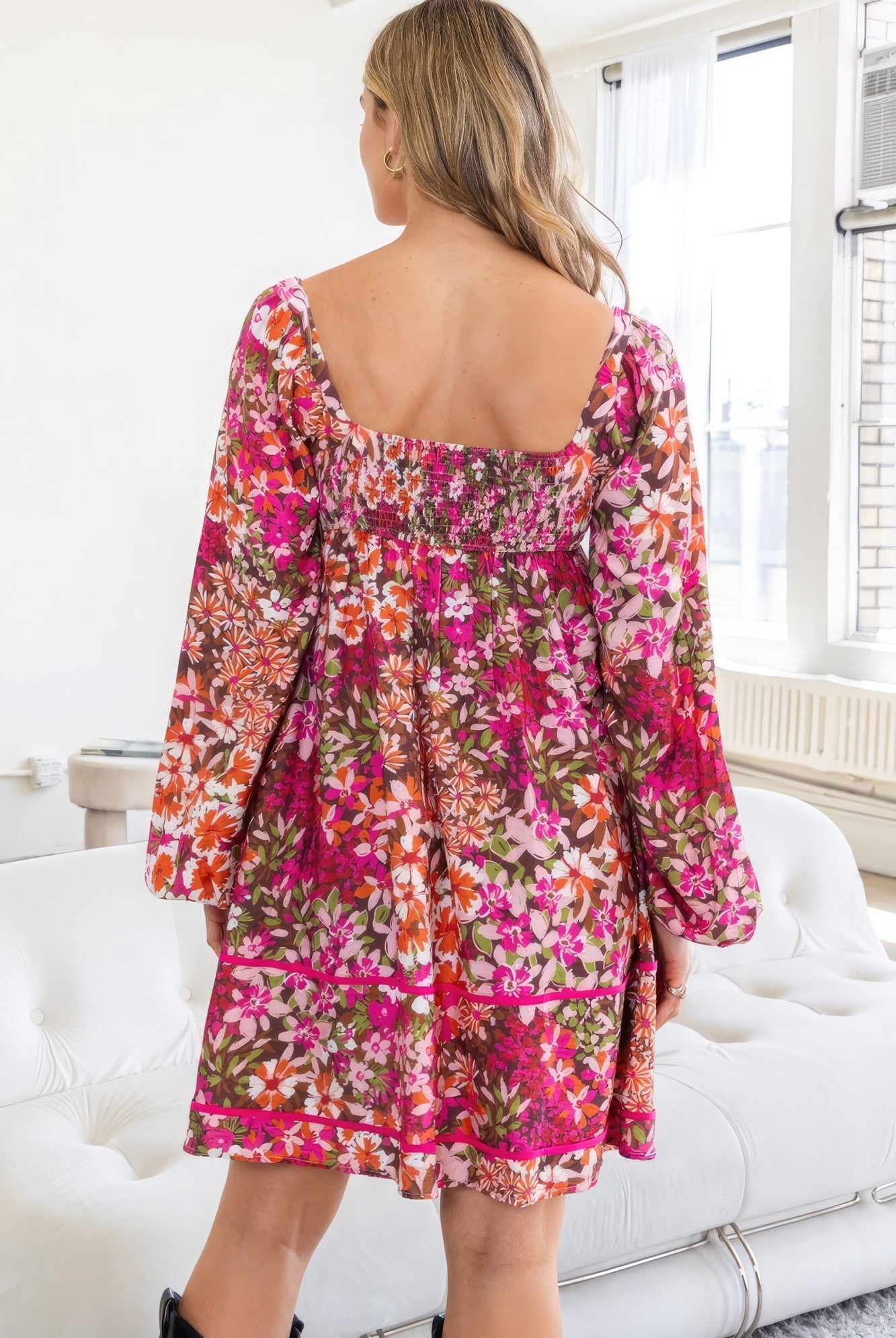 Back view of AVAH Vivid Bloom Floral Long Sleeve Mini Dress with smocked detail and tiered silhouette.