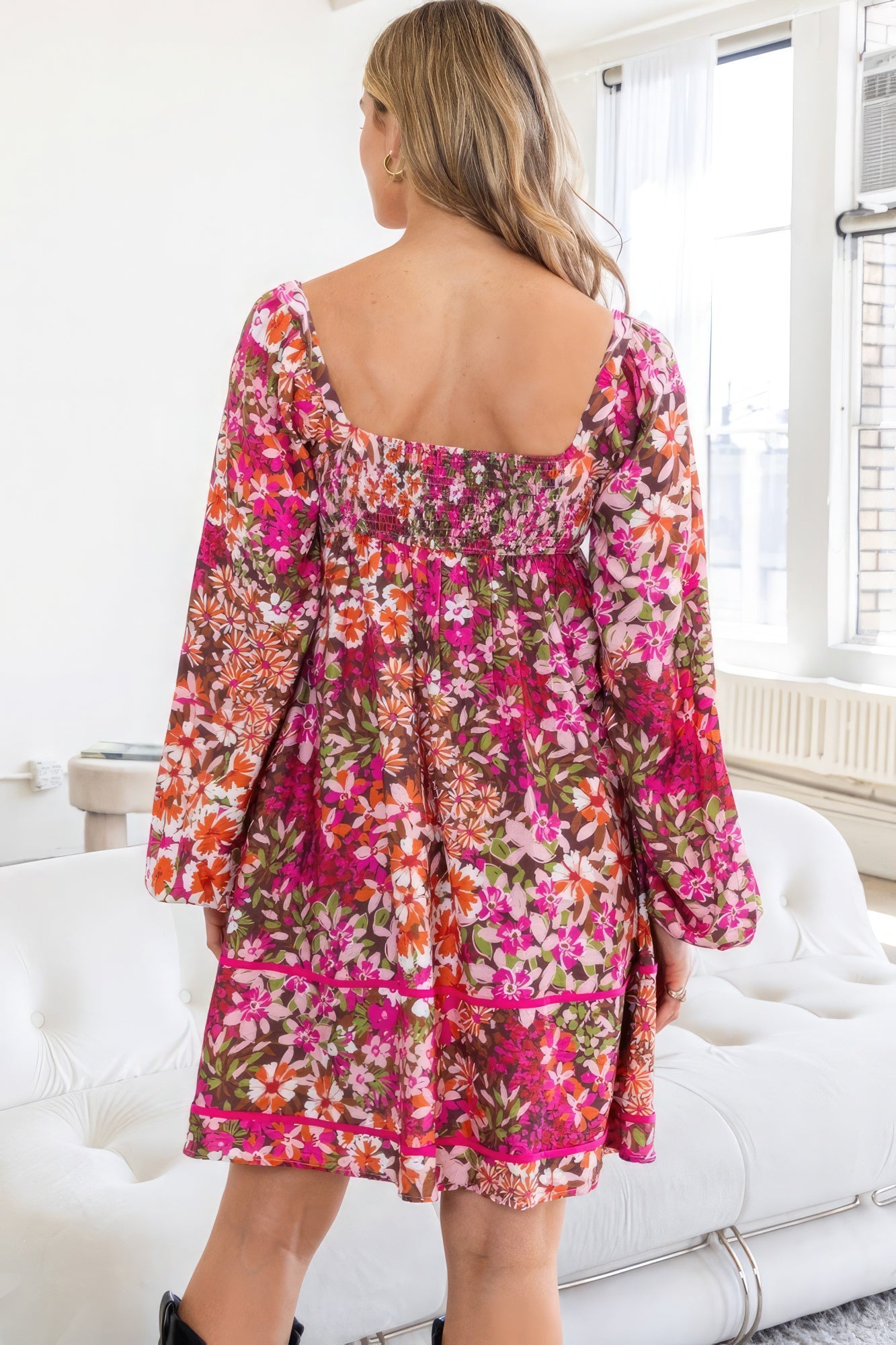 Back view of AVAH Vivid Bloom Floral Long Sleeve Mini Dress with smocked detail and tiered silhouette.
