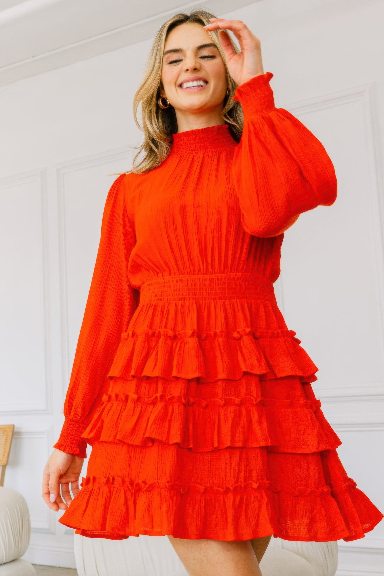 Model smiling in vibrant red tiered ruffle dress with high neckline and long sleeves-AVAH