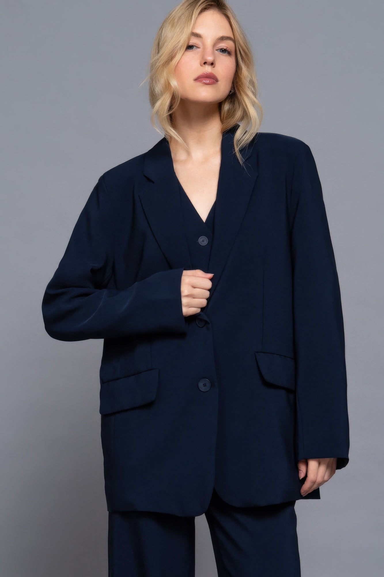 Close-up of oversized navy blazer showing button details and flap pockets-AVAH