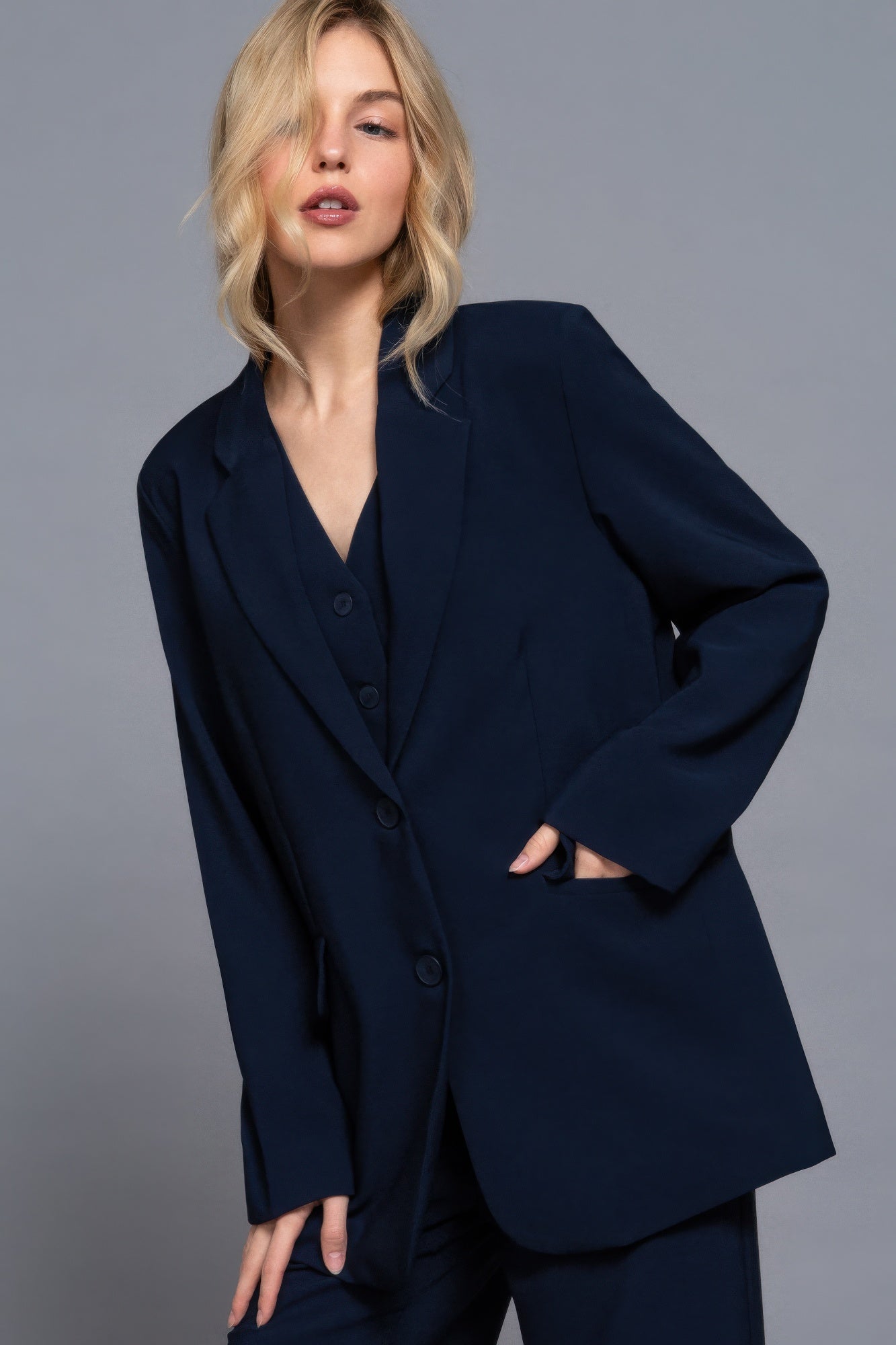 Side angle of oversized navy blazer styled over matching vest-AVAH