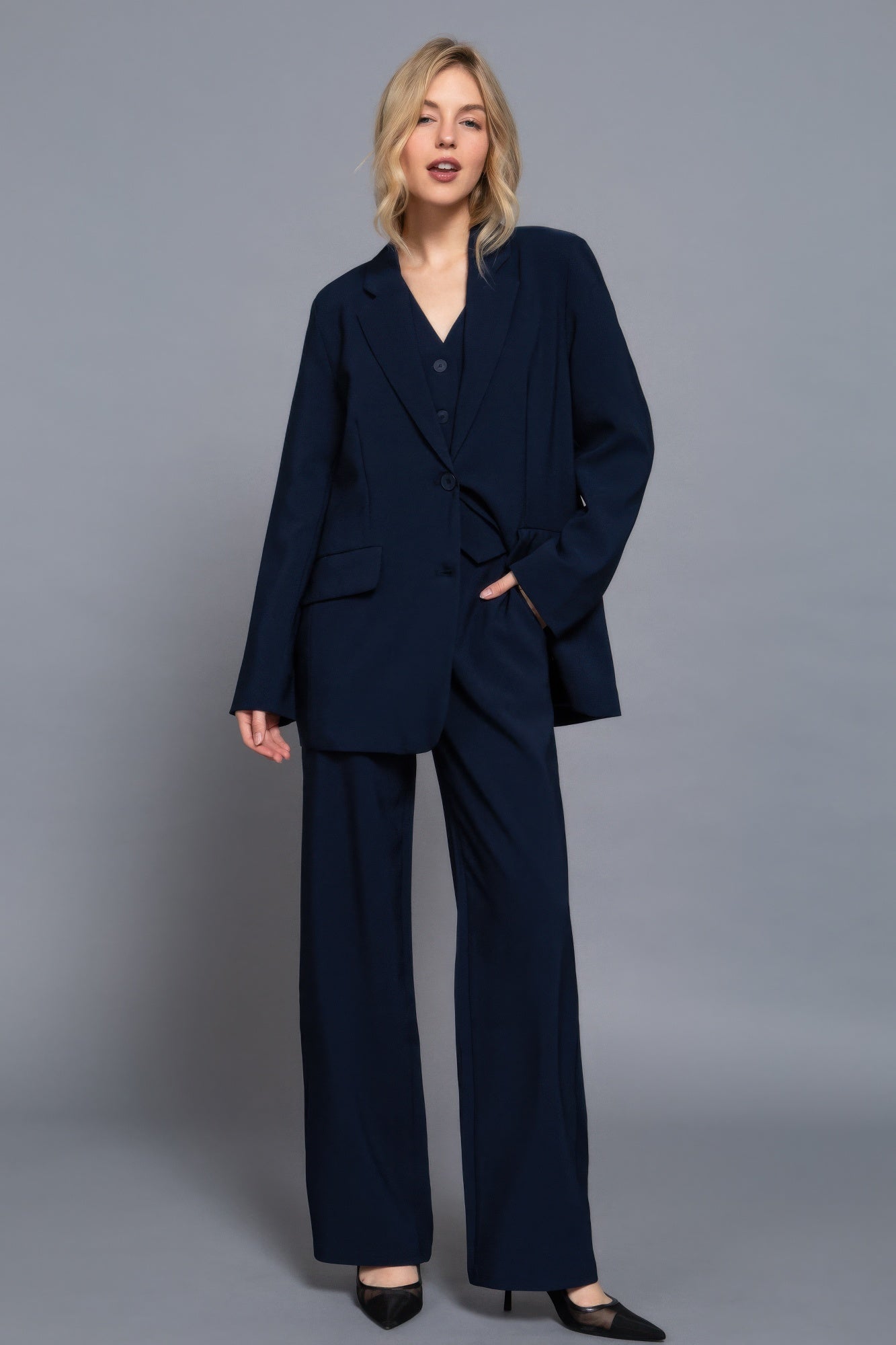 Model wearing navy straight-leg pants styled with matching blazer and vest-AVAH