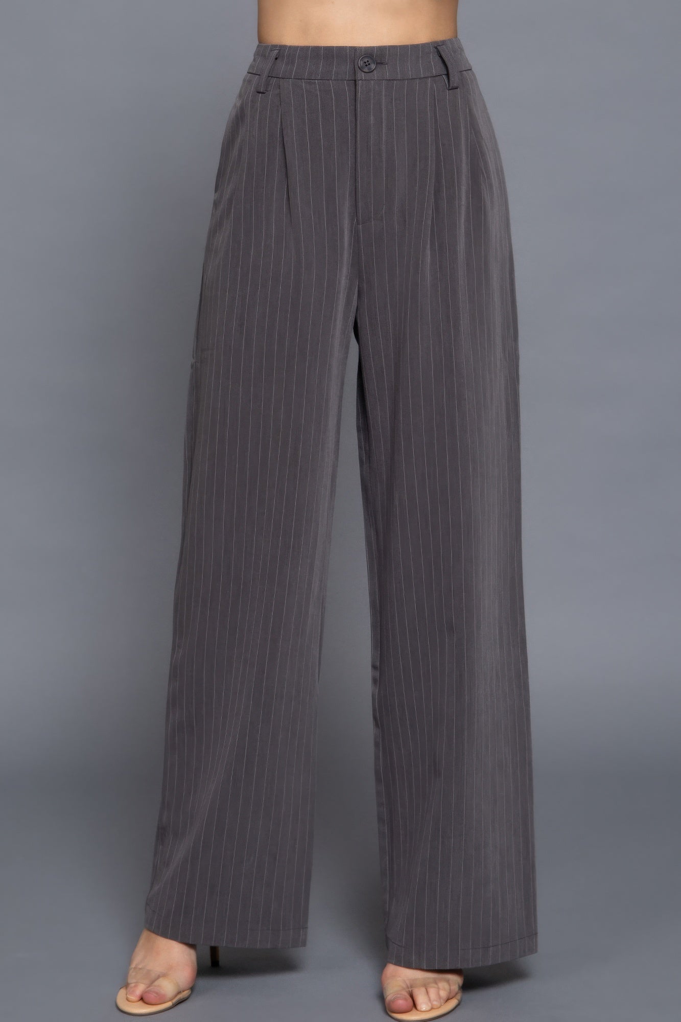 Waist-up detail of charcoal pinstripe trousers showing waistband, button, and vertical stripe pattern.