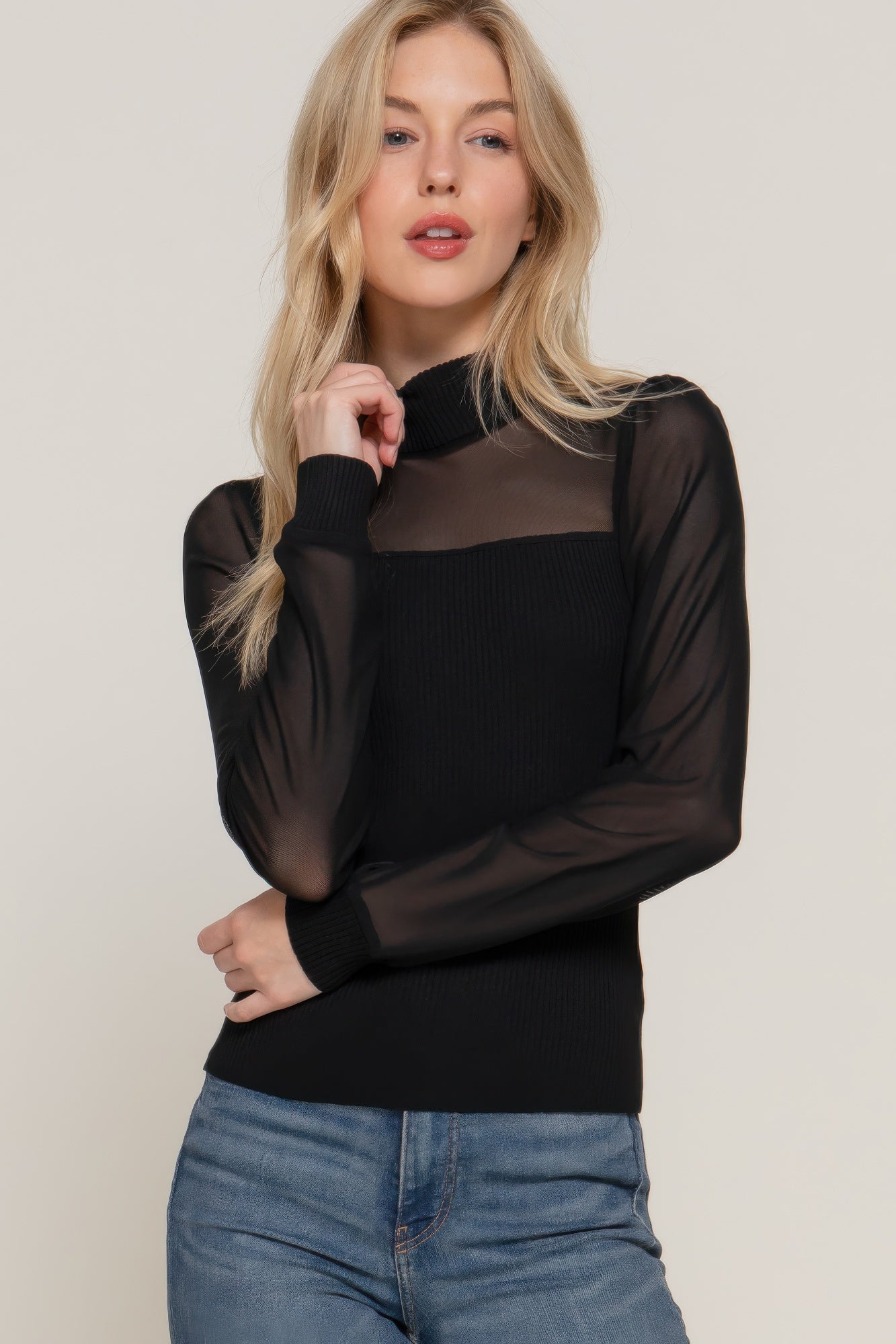 Woman wearing a black soft ribbed knit sweater top with a wide neckline and relaxed fit, styled with neutral pants – minimal and chic everyday look-AVAH