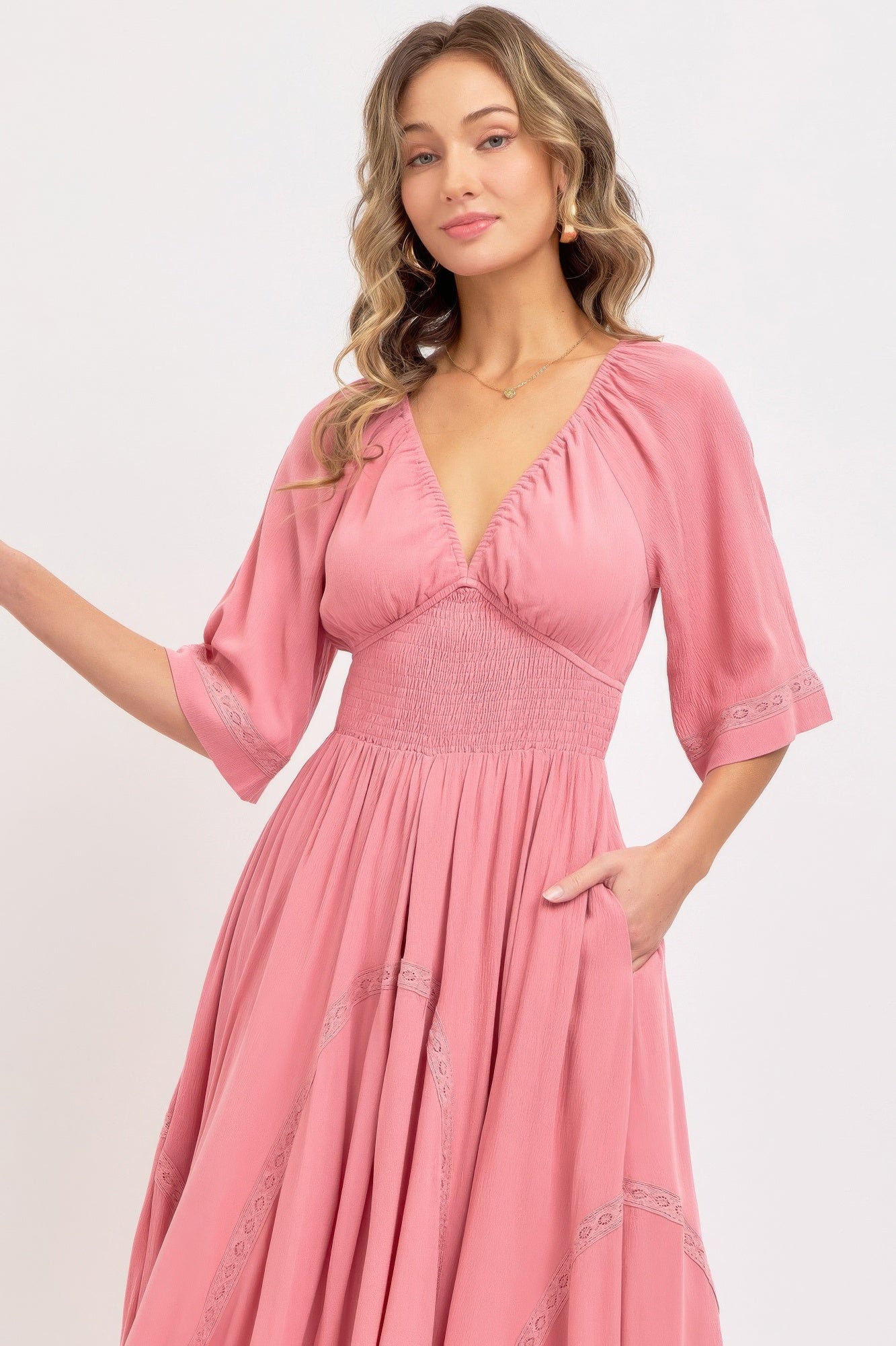 Close up of v-neck and smocked bodice of flowy pink maxi dress