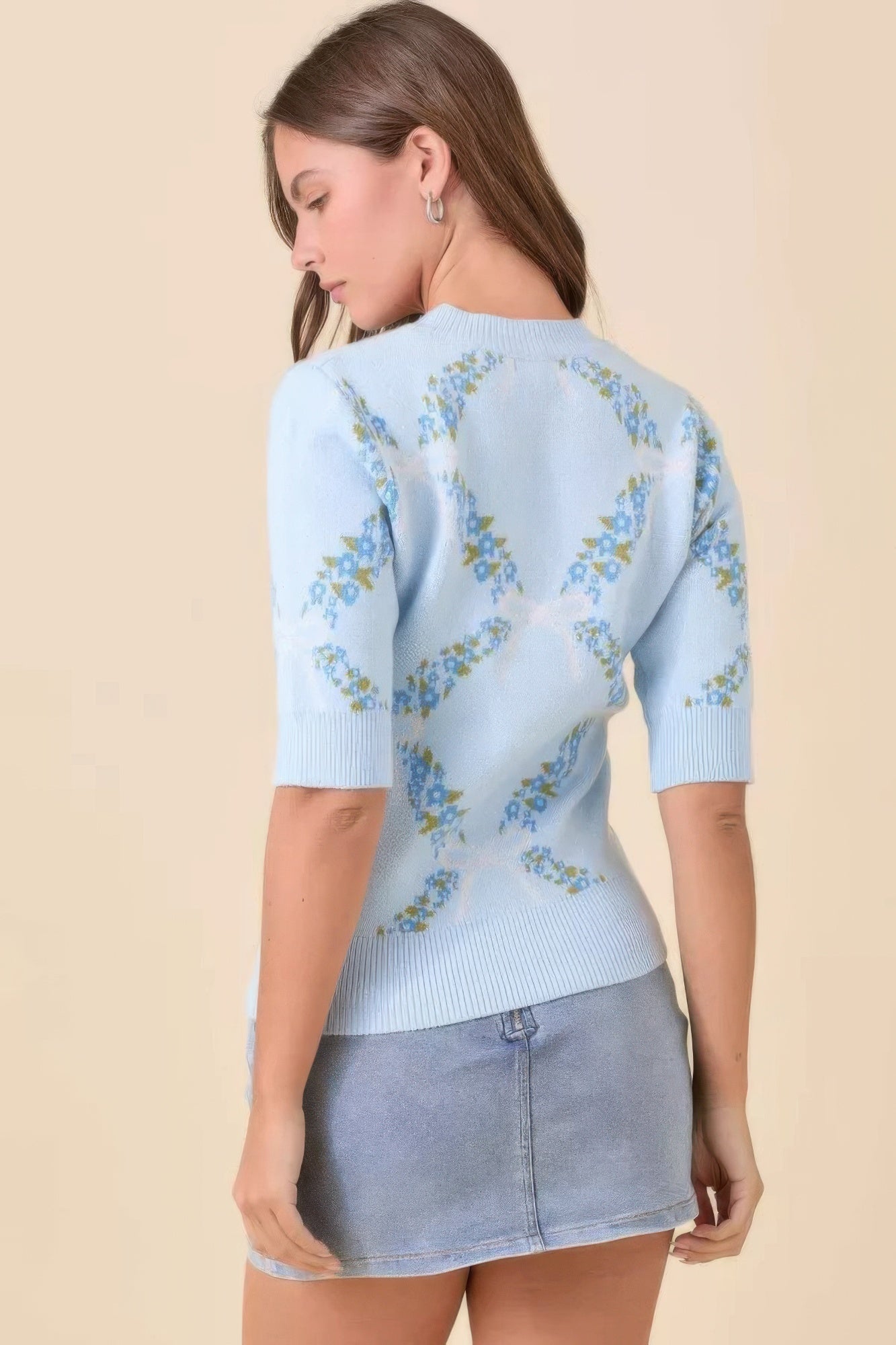 Back view of light blue floral knit short sleeve sweater.