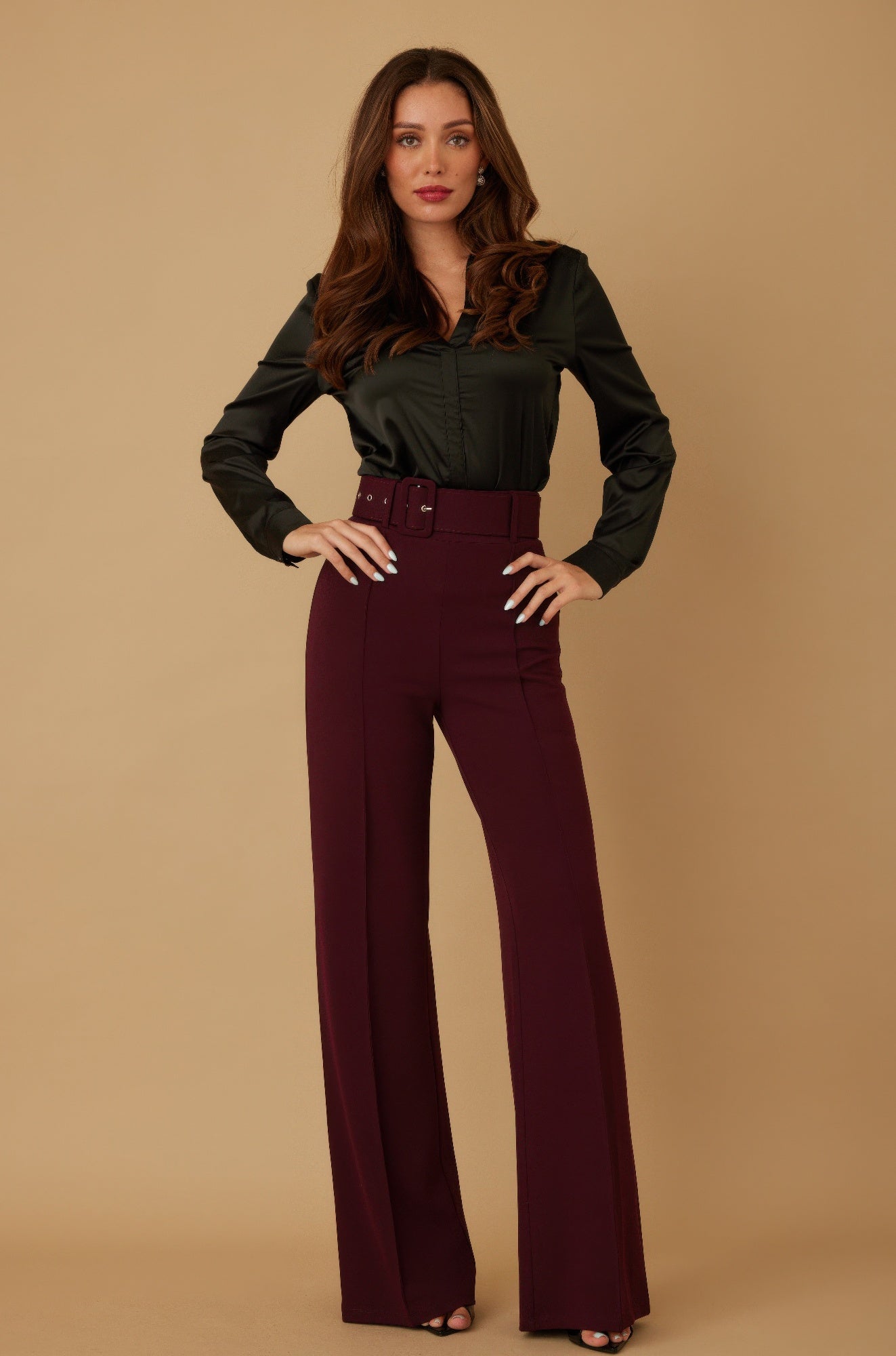 Woman wearing burgundy high waist wide leg pants with matching belt