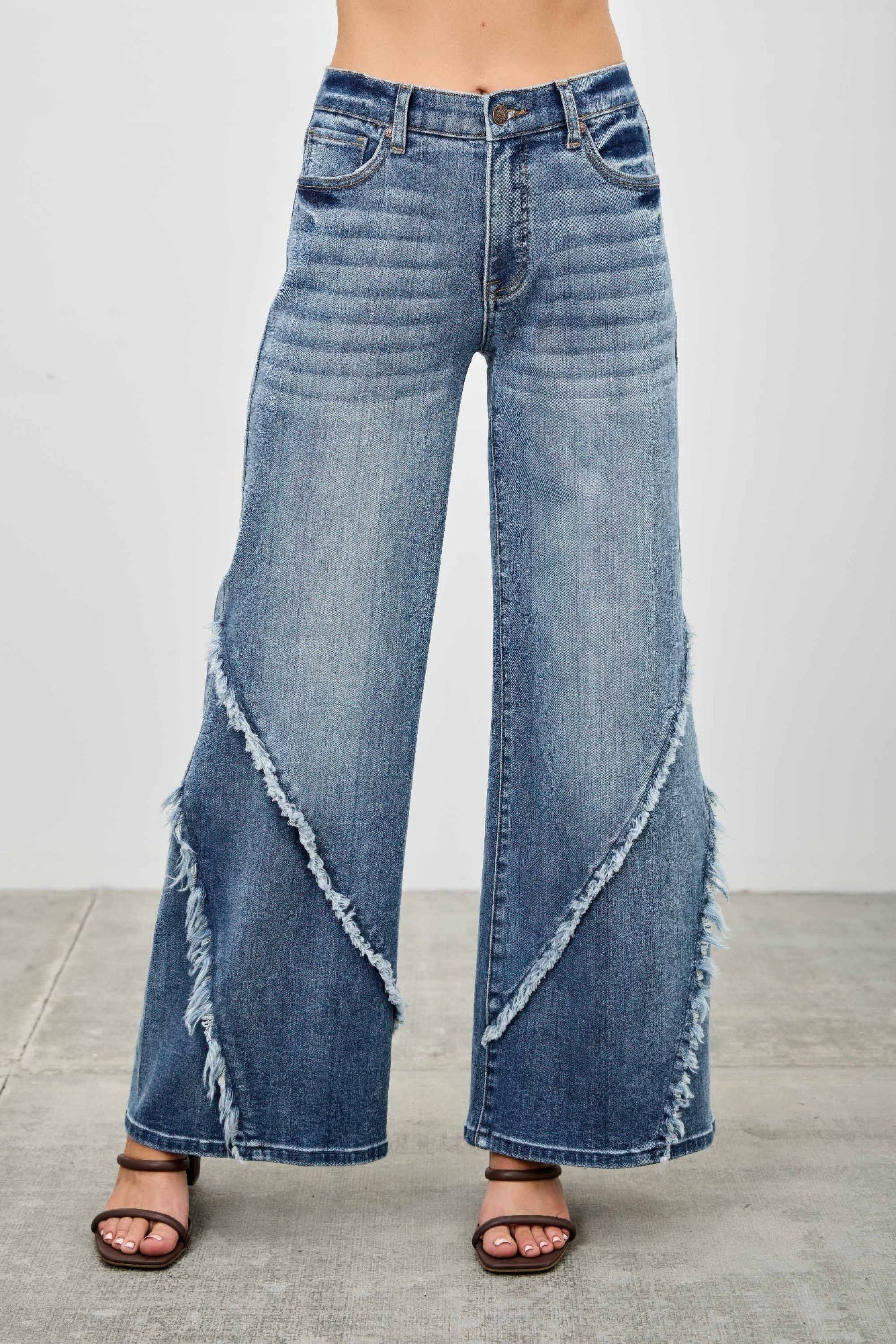 Wide leg blue denim jeans front view with distressed diagonal seam detailing