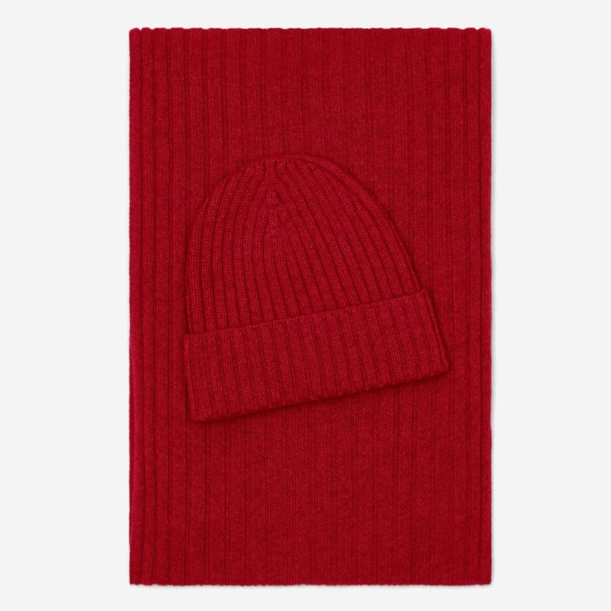 Red knit hat on a red rectangular blanket with a white background