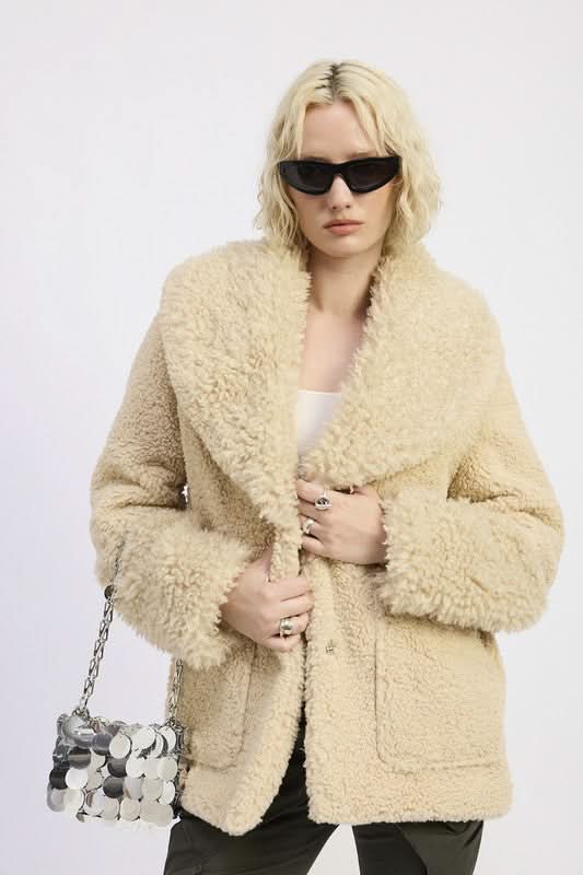 Model wearing oversized faux shearling teddy coat in beige taupe with sunglasses