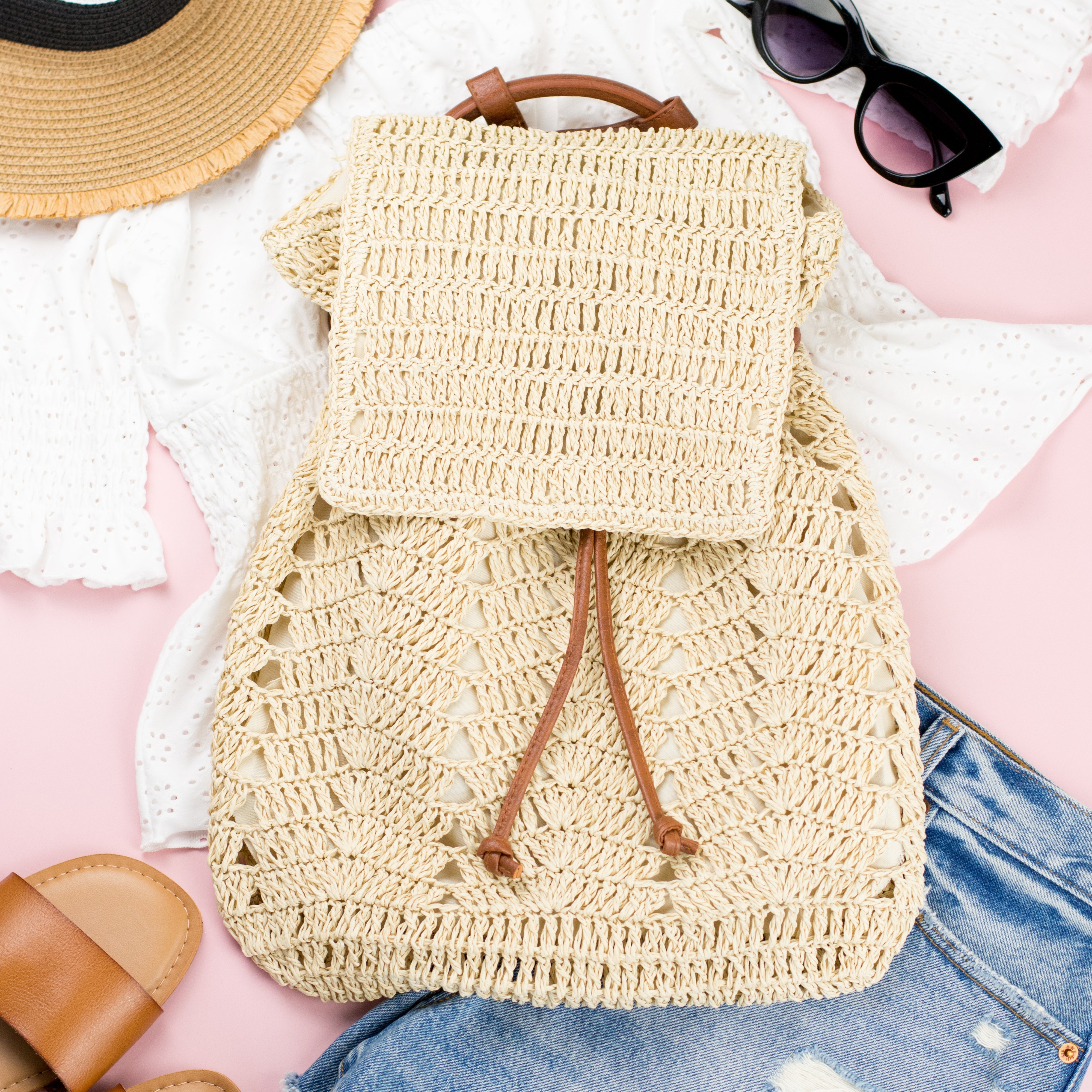 AVAH-close up of cream woven crochet backpack with brown leather straps