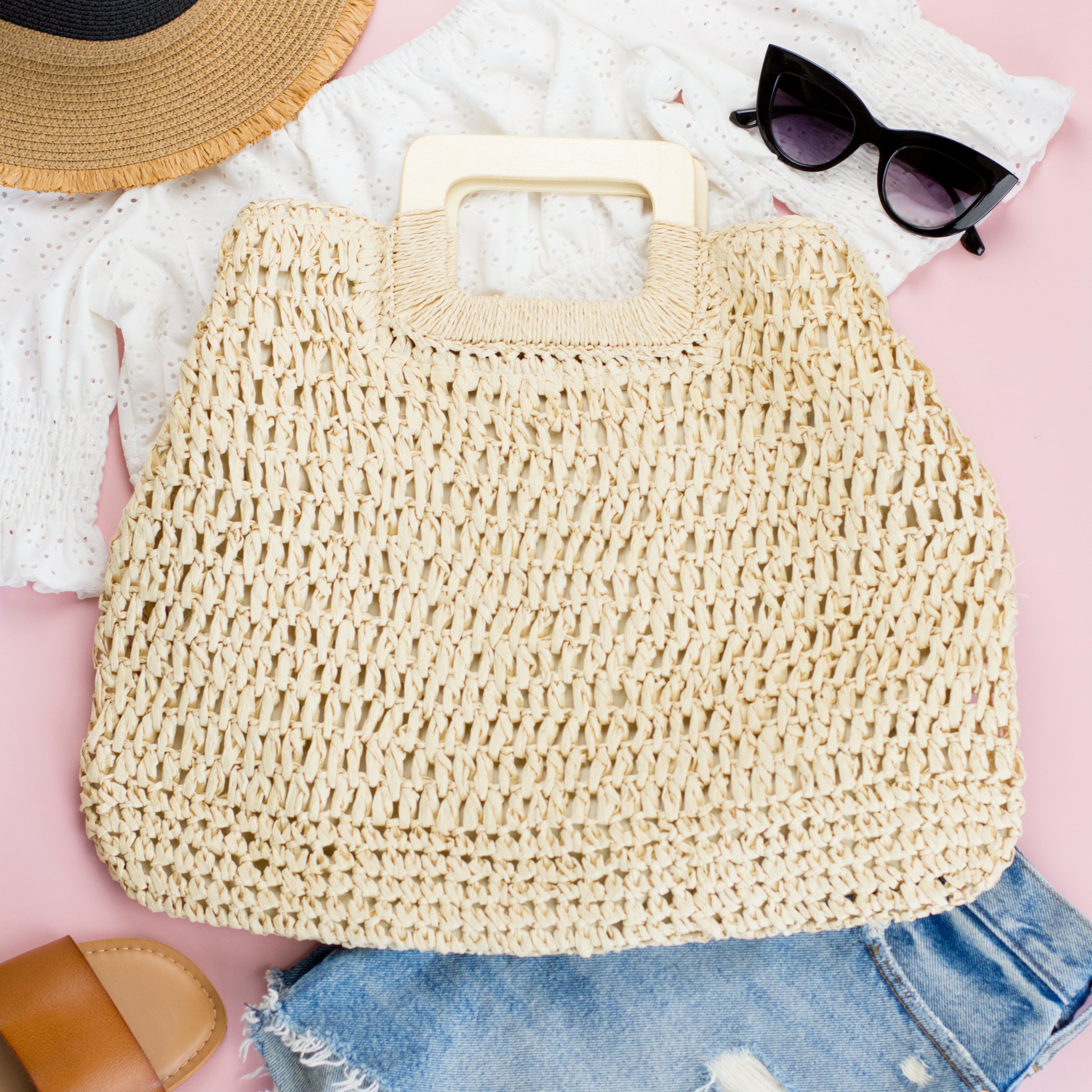 100% natural straw tote with wooden handles, top zipper closure, and a small sidewall pocket in cream
