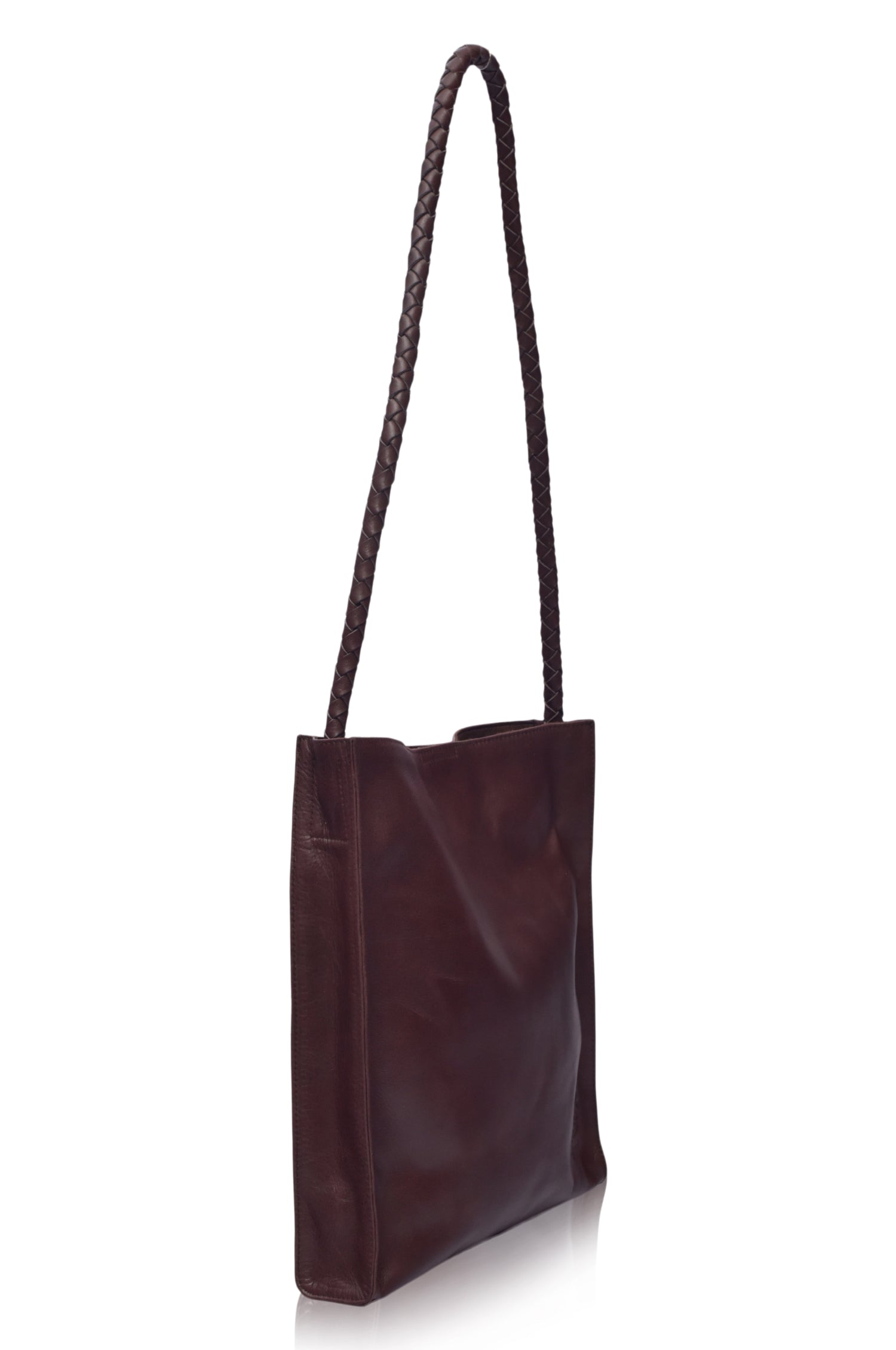 Brown leather tote bag with a long handle on a white background